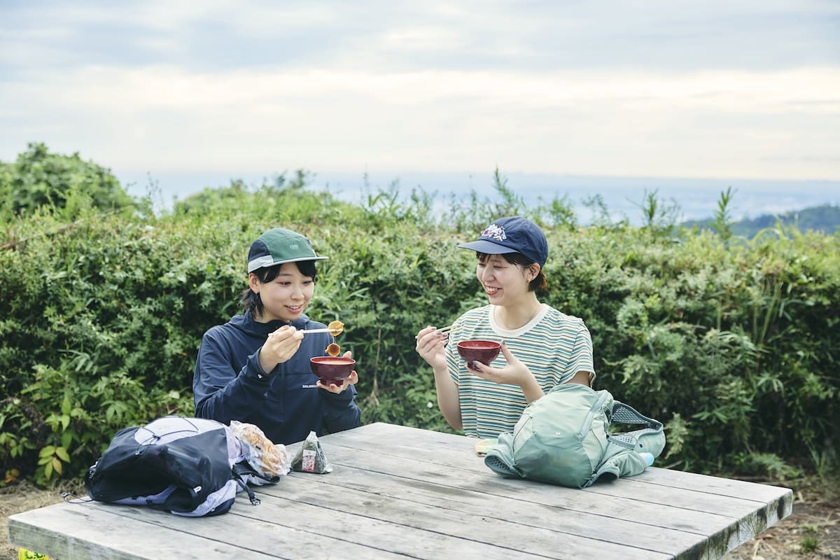 小仏城山の山頂の茶屋で名物のなめこ汁を味わうおふたり。